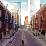 A picture of downtown Denver with buildings lining both the left and right sides of the street